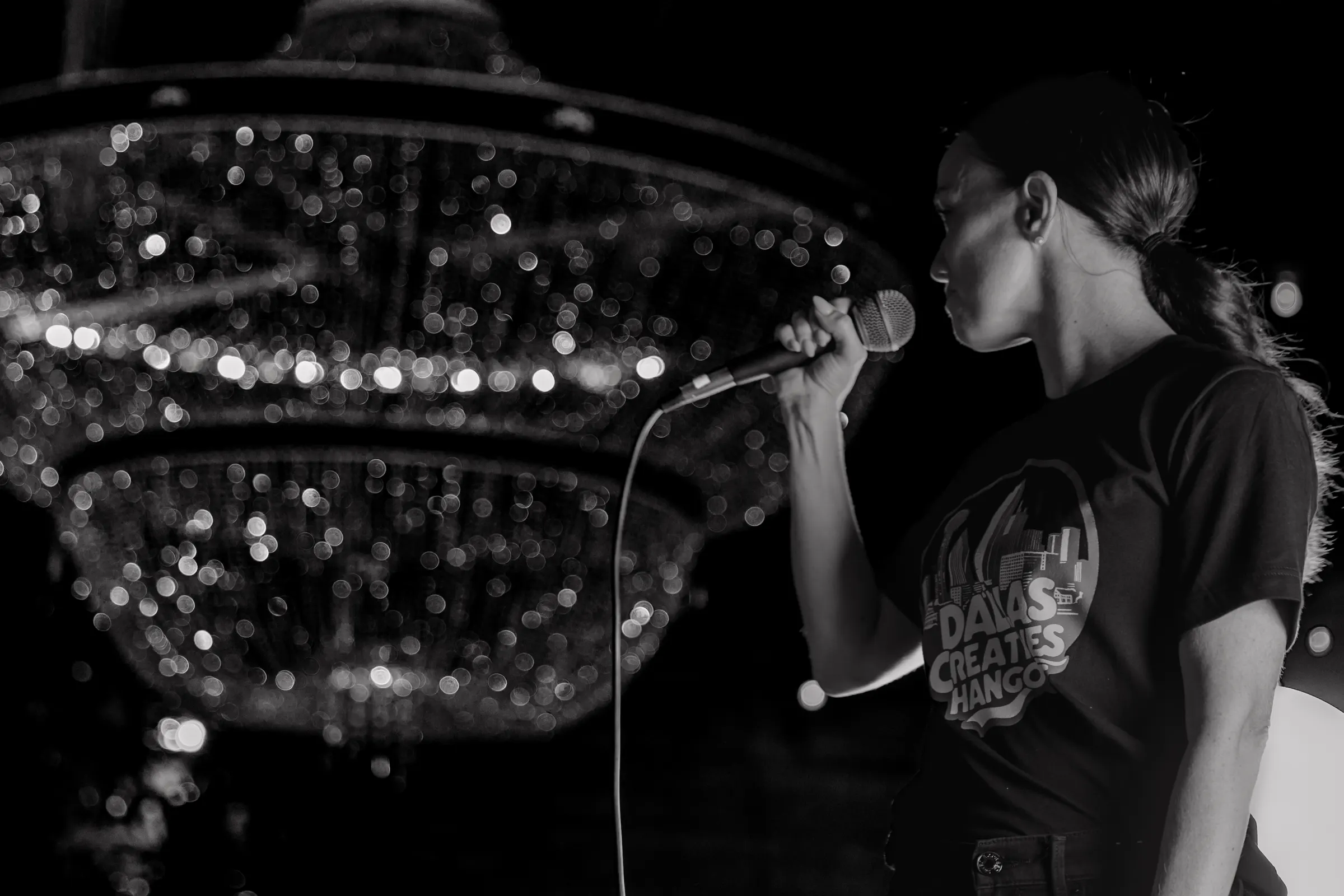 A singer performing under a chandelier
