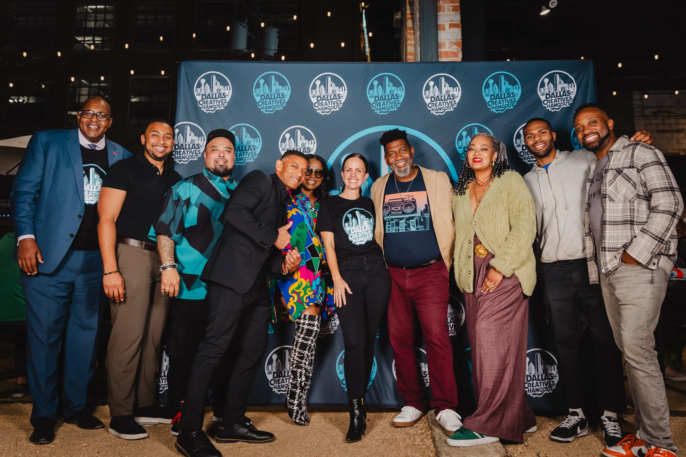 A big group photo in front of the Hangout backdrop